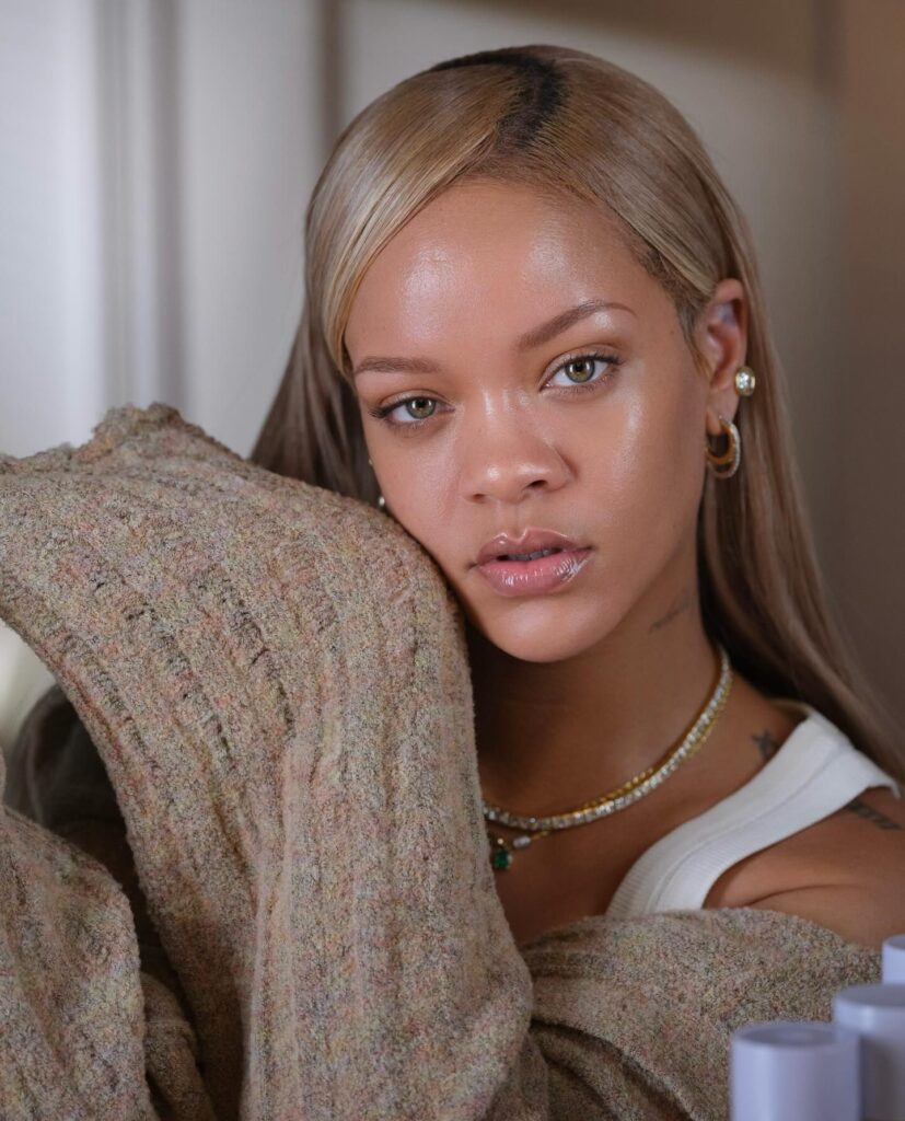 Rihanna poses close-up, wearing a cozy sweater, showcasing her natural beauty.