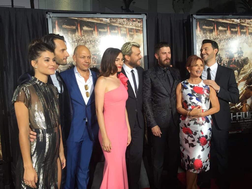 Cast members in formal attire posing together on a red carpet at the Ben-Hur premiere.