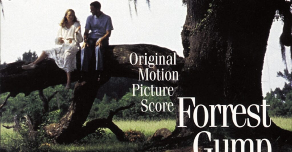 Jenny and Forrest Gump sitting on a large, moss-covered oak tree branch.