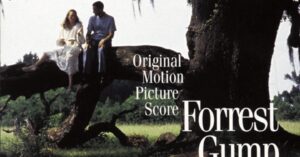 Jenny and Forrest Gump sitting on a large, moss-covered oak tree branch.