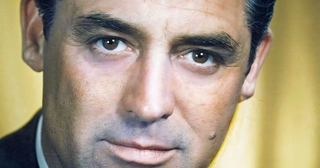 A classic black and white studio portrait of Cary Grant in a military uniform, featuring a side-parted hairstyle and a slight, charismatic smile.